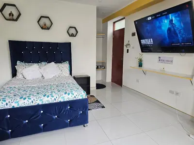 a bedroom with a bed and a flat screen tv at PIERO HOUSE - La Merced in La Merced