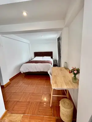 a bedroom with a bed and a wooden floor at La Maison Samaï in Urubamba