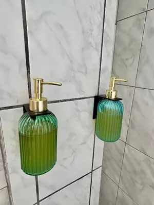 two green glass vases on a wall in a bathroom at La Maison Samaï in Urubamba