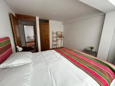 a bedroom with a large white bed in a room at La Maison Samaï in Urubamba