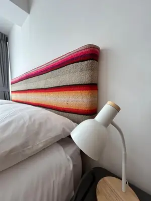 a bedroom with a bed with a pillow and a lamp at La Maison Samaï in Urubamba