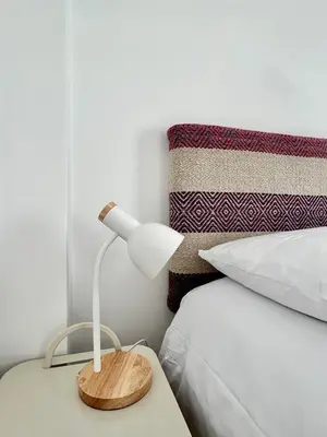 a lamp on a table next to a bed at La Maison Samaï in Urubamba