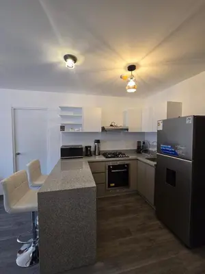 a kitchen with a counter and a refrigerator and a stove at Acogedor Departamento en Cusco, Ideal para Familias y Amigos, Equipado y Céntrico in Cusco