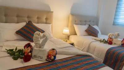 two beds with dolls on them in a bedroom at Acogedor Departamento en Cusco, Ideal para Familias y Amigos, Equipado y Céntrico in Cusco