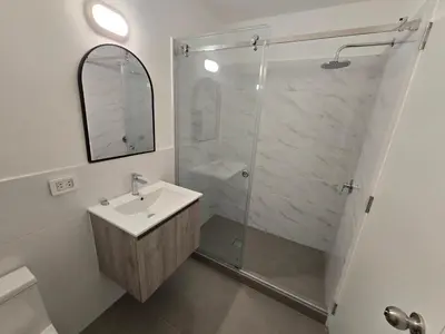 a white bathroom with a shower and a sink at Acogedor Departamento en Cusco, Ideal para Familias y Amigos, Equipado y Céntrico in Cusco