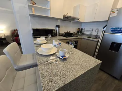 a kitchen with a counter with plates and glasses on it at Acogedor Departamento en Cusco, Ideal para Familias y Amigos, Equipado y Céntrico in Cusco