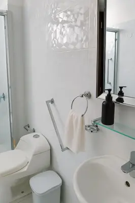 a white bathroom with a toilet and a sink at Bello departamento frente a Larcomar Miraflores in Lima