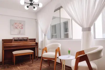 a living room with a piano and chairs and a table at Bello departamento frente a Larcomar Miraflores in Lima