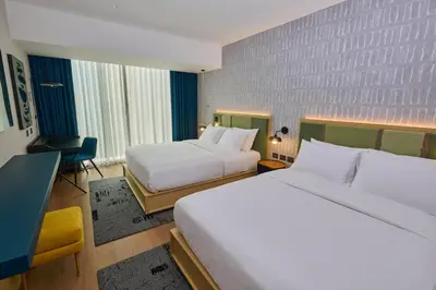 a hotel room with two beds and a desk at Hotel Indigo Lima Miraflores by IHG in Lima