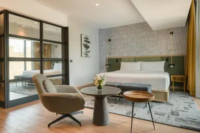 a hotel room with a bed and a table and chairs at Hotel Indigo Lima Miraflores by IHG in Lima