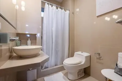 a white bathroom with a toilet and a sink at GRM302 Apt Moderno 2 DRM with KING Bed in Miraflores in Lima