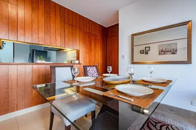 a dining room with a table and chairs and a mirror at GRM302 Apt Moderno 2 DRM with KING Bed in Miraflores in Lima