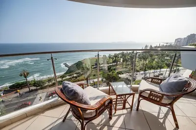 a balcony with chairs and a view of the ocean at M1001 - Malecon Seaview 2BDR Miraflores in Lima