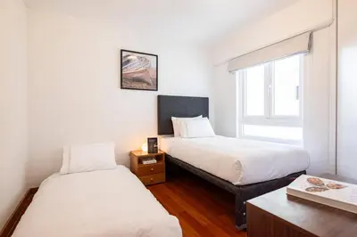 two beds in a small room with a window at M1001 - Malecon Seaview 2BDR Miraflores in Lima