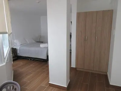 a bedroom with a bed and a wooden cabinet at Venue Apartments in Lima