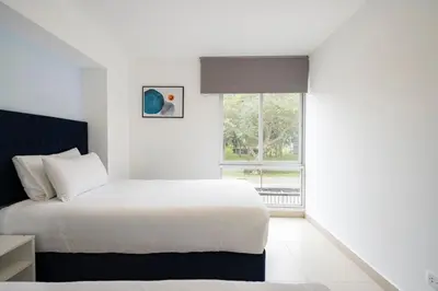 a white bedroom with a bed and a window at Reducto - Beautiful 3 BRD Front of Miraflores biggest Park in Lima