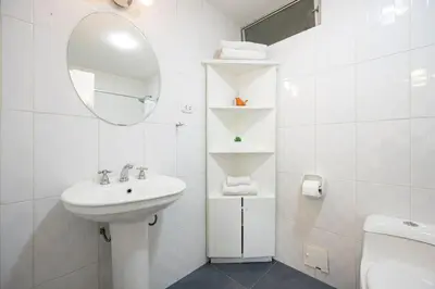 a white bathroom with a sink and a mirror at Reducto - Beautiful 3 BRD Front of Miraflores biggest Park in Lima