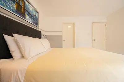 a white bedroom with a large bed with white pillows at Reducto - Beautiful 3 BRD Front of Miraflores biggest Park in Lima