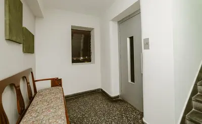 a hallway with a table and chairs and a door at Romanet - Depa Premium con Vista al Golf in Lima