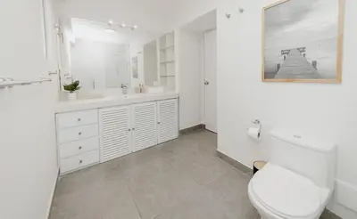 a white bathroom with a toilet and a sink at Romanet - Depa Premium con Vista al Golf in Lima