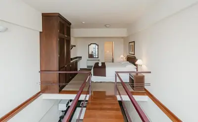 a large bedroom with a bed and a staircase at Alcanfores - Tu Escapada Urbana Perfecta in Lima