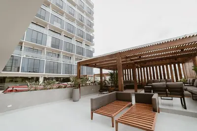 a patio with a bench and a large building at Alcanfores - Tu Escapada Urbana Perfecta in Lima