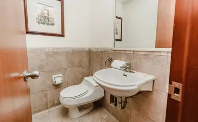a bathroom with a white toilet and a sink at Alcanfores - Tu Escapada Urbana Perfecta in Lima