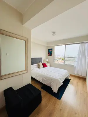 a bedroom with a bed and a large window at Apartamento moderno en San Miguel in Lima