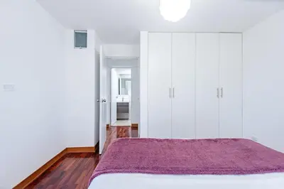 a bedroom with white cabinets and a purple bed at Benavides - Amplio departamento funcional de 3 hab en Av Principal in Lima