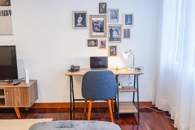 an office with a desk with a chair and a television at Benavides - Amplio departamento funcional de 3 hab en Av Principal in Lima