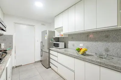 a kitchen with white cabinets and a stainless steel refrigerator at Benavides - Amplio departamento funcional de 3 hab en Av Principal in Lima