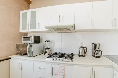 a white kitchen with a stove and a microwave at GRM1601 Modern 1 BDR with skyline views from Miraflores in Lima