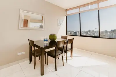 a dining room with a table and chairs and a large window at GRM1601 Modern 1 BDR with skyline views from Miraflores in Lima