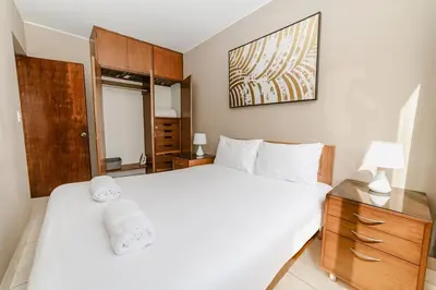 a bedroom with a large white bed with a glass cabinet at GRM1601 Modern 1 BDR with skyline views from Miraflores in Lima