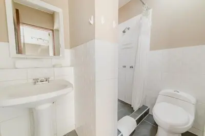 a white bathroom with a toilet and a sink at GRM1601 Modern 1 BDR with skyline views from Miraflores in Lima
