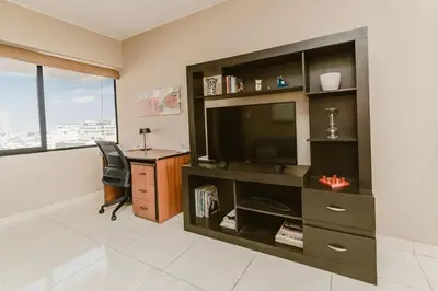 a living room with a desk and a television and a deskictericterictericter at GRM1601 Modern 1 BDR with skyline views from Miraflores in Lima