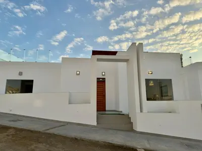 a white building with a red door on it at Beach house Sol Mar y Relax in Cerro Azul