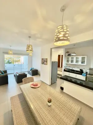 a living room with a table and a kitchen at Beach house Sol Mar y Relax in Cerro Azul
