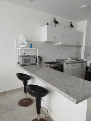 a kitchen with two bar stools and a counter top at Excellent view of Mar San Bartolo in San Bartolo