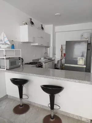 a kitchen with a counter with two bar stools at Excellent view of Mar San Bartolo in San Bartolo