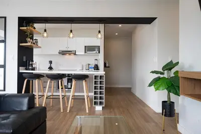 a kitchen and living room with a counter and stool at Balta - Apartment with Panoramic View in Kennedy Park in Lima