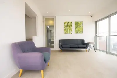 a living room with two chairs and a couch at Balta - Apartment with Panoramic View in Kennedy Park in Lima