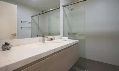 a bathroom with a sink and a shower with a mirror at Balta - Apartment with Panoramic View in Kennedy Park in Lima