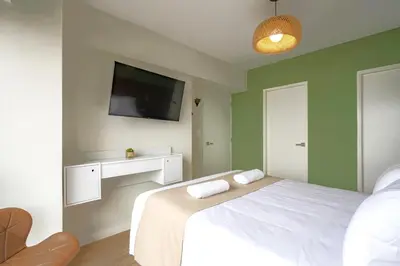 a bedroom with a white bed and a flat screen tv at Balta - Apartment with Panoramic View in Kennedy Park in Lima