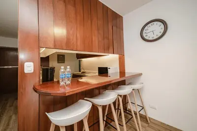 a kitchen with a bar with stools and a clock at GRM308 Bright 2BR with BIG Terrace in Heart of Miraflores in Lima