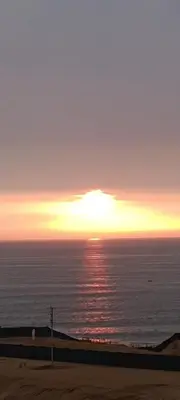 a sunset over the ocean with the sun setting at Dpto de Playa Miramar San Bartolo in San Bartolo