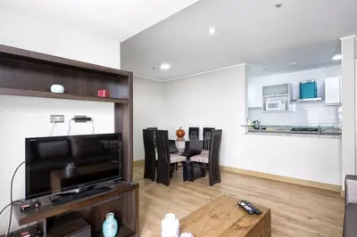 a living room with a television and a table at Wasi Apartment Pardo in Lima