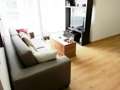 a living room with a couch and a tv at Wasi Apartment Pardo in Lima