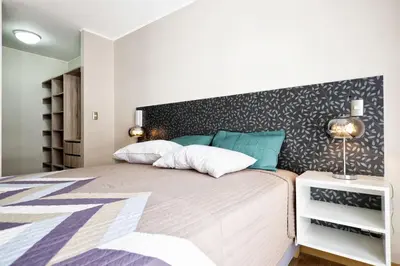 a bedroom with a large bed with a black accent wall at Wasi Apartment Pardo in Lima