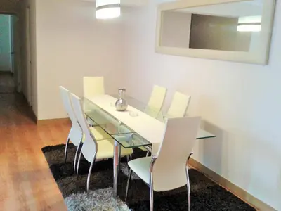 a dining room with a glass table and white chairs at Peru Rent Apart com pe in Lima